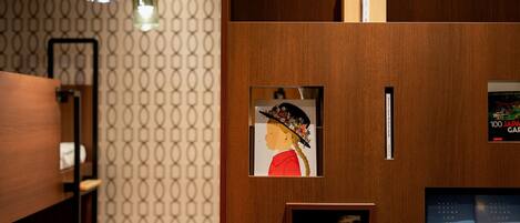 A wooden wall with framed artwork, a guidebook, and a shelf with decorative items.