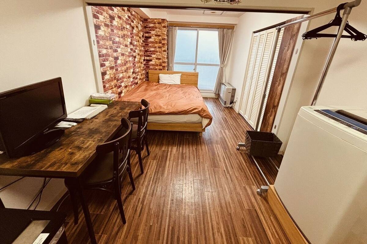 A compact room with a bed, a desk, and a chair.
