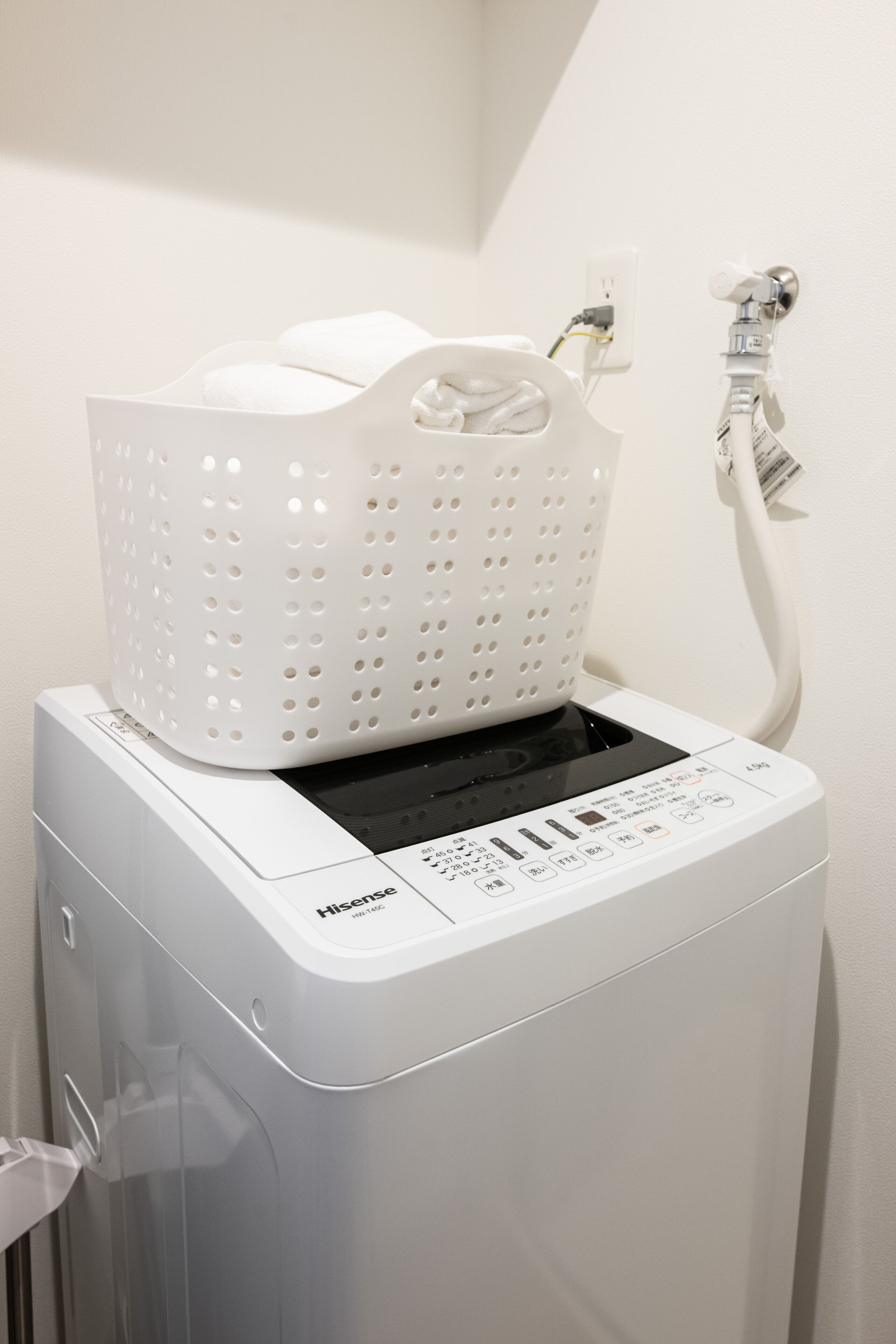 A front-loading washing machine with a white basket on top.