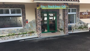 Ken's Beachfront Cafe with a tiled roof, stone facade, and a green door. - Beach Lodge 2 & Private Beach (Onna)