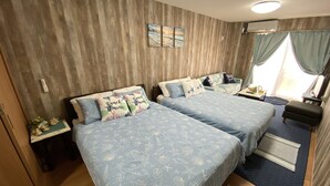 A bedroom with two beds, a nightstand, a dresser, a window with curtains, and a wall-mounted air conditioner. - Beach Lodge 2 & Private Beach (Onna)