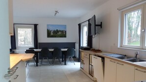 Una cocina moderna con comedor, un ventanal grande y un cuadro en la pared.