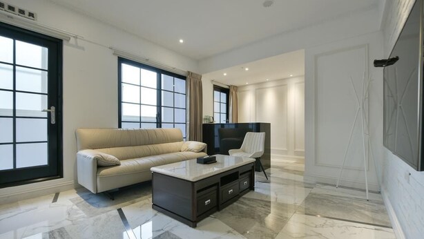A modern living room with a sofa, a coffee table, and a TV. - Fengjia Gold Hotel (Taichung)