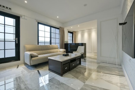 Deluxe Quadruple Room, Bathtub | Living room | 42-inch LCD TV with digital channels, TV