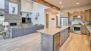 Una cocina moderna con una isla central, armarios de madera y una pared decorativa de piedra.