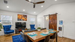 A dining area with a wooden table, blue chairs, and a blue rug.