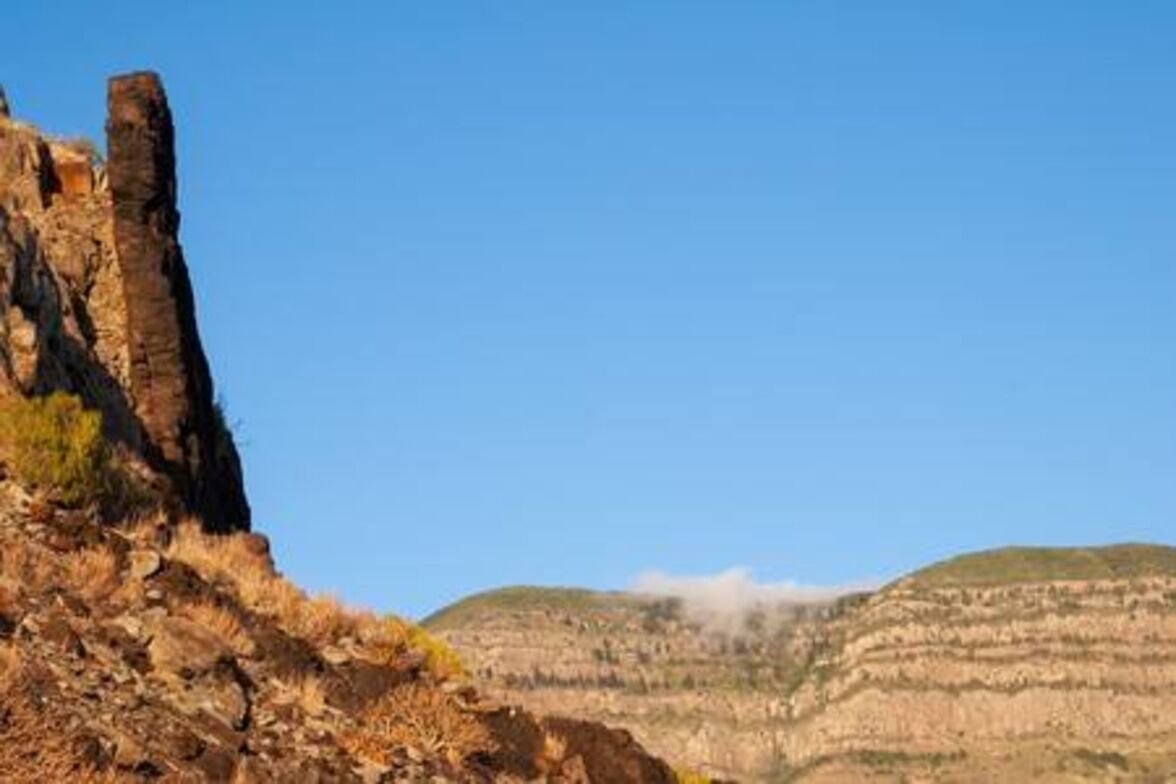 Une falaise rocheuse sous un ciel dégagé.