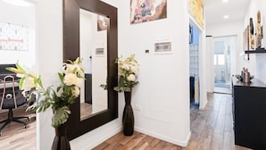 A modern interior with a large mirror, two vases with flowers, and artwork on the walls. - GuestHost - Located in the heart of the city, near the places of greatest cultural interest and a few steps from the Santa Maria Novella station, it is the ideal place for tourist or business stays.The area of ​​Borgo Ognissanti reflects the ancient  (Florence)