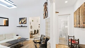 A modern living room with a sofa, coffee table, and a dining area with chairs. - GuestHost - Located in the heart of the city, near the places of greatest cultural interest and a few steps from the Santa Maria Novella station, it is the ideal place for tourist or business stays.The area of ​​Borgo Ognissanti reflects the ancient  (Florence)