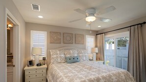A bedroom with a bed, nightstands, a ceiling fan, and a view of the outside. - Beautiful Updated House with Ocean Views in Downtown Pismo (Pismo Beach)