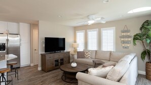 A modern living room with a sofa, coffee table, and a flat-screen TV. - Beautiful Updated House with Ocean Views in Downtown Pismo (Pismo Beach)