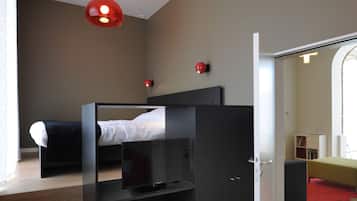 Un dormitorio moderno con una cama litera, un televisor de pantalla plana y una lámpara colgante roja.