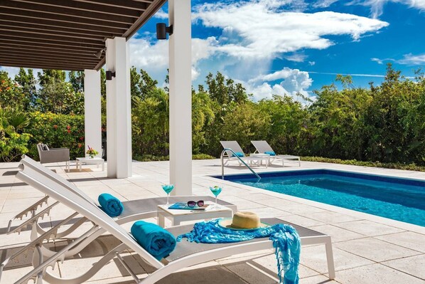 Alberca al aire libre y camastros