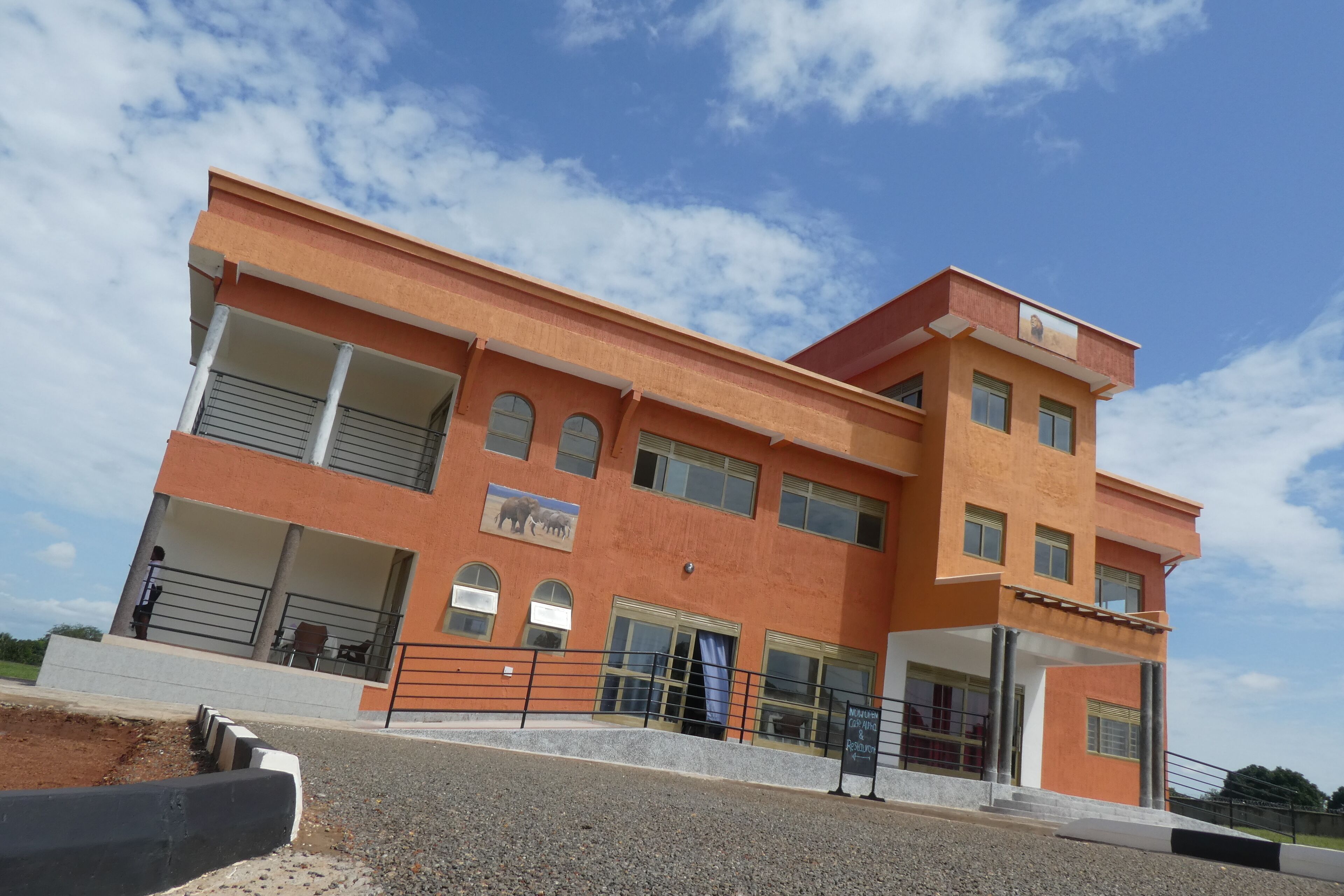 A multi-story building with a flat roof, large windows, and a balcony.
