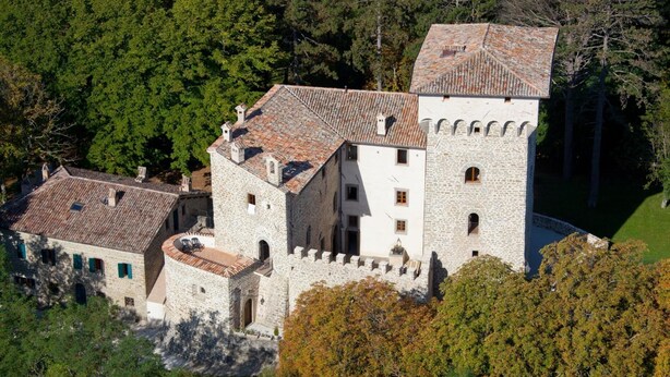 A medieval-style stone castle with a central tower, surrounded by lush greenery. - Castello Degli Arcieri (Gubbio)
