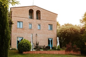 A two-story brick building with arched windows and a balcony.