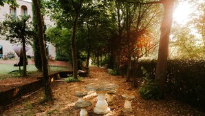 A garden pathway with stone planters and trees. - Villa Collina Sul Mare (Porto San Giorgio)