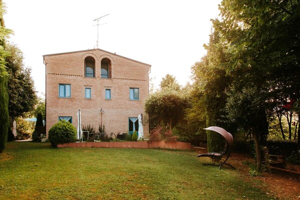 A brick building with a flat roof, multiple windows, and a central antenna.