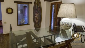 A glass-top table with a telephone, a decorative lamp, and a vase on it. - Villa Antico Incanto (Monte Castello di Vibio)