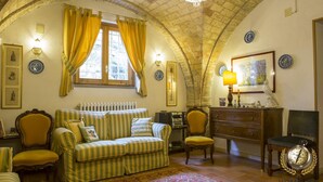 A cozy room with a striped sofa, a wooden cabinet, and a vintage radio. - Villa Anna (Giulianova)