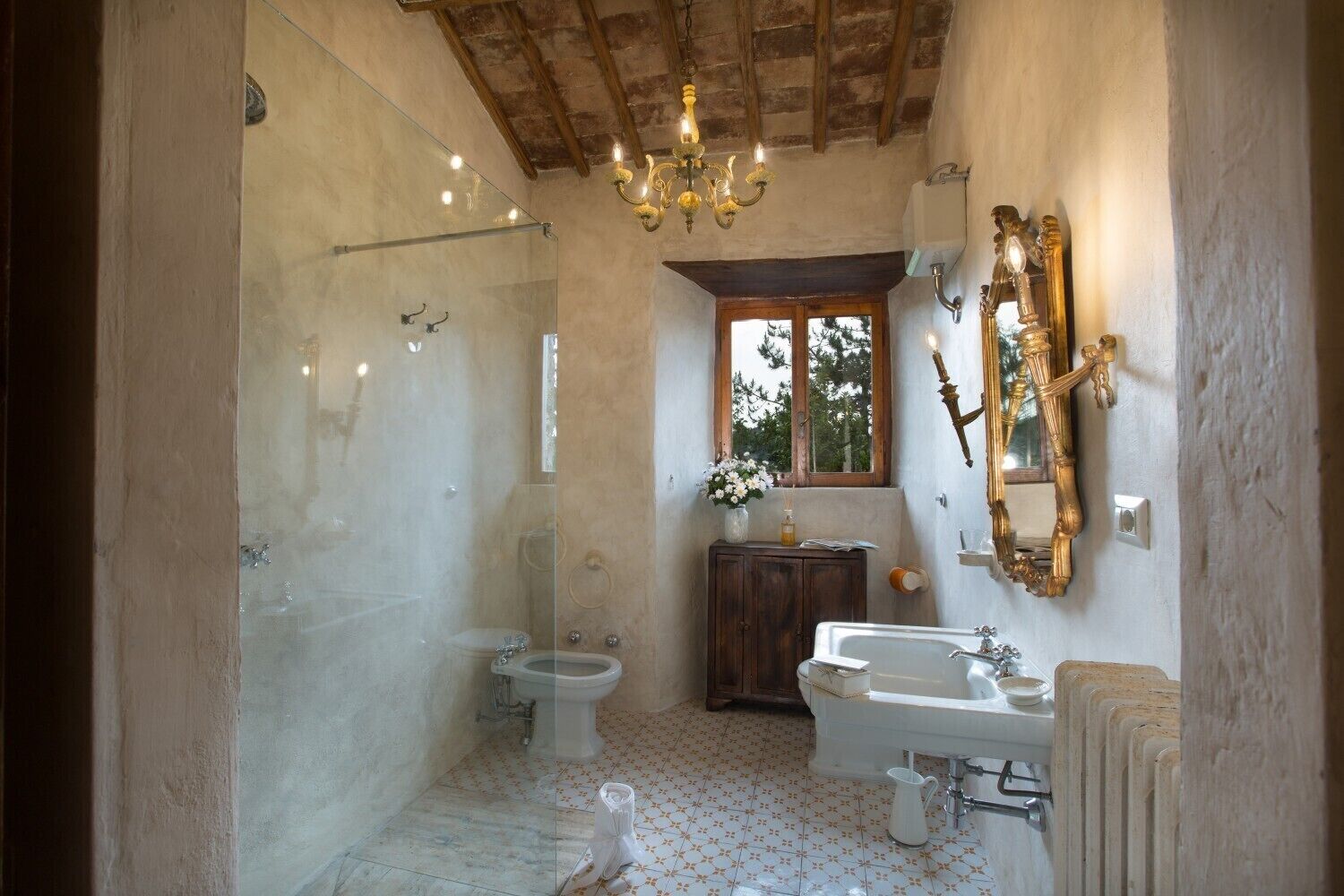 A bathroom with a shower, toilet, sink, and a large mirror.