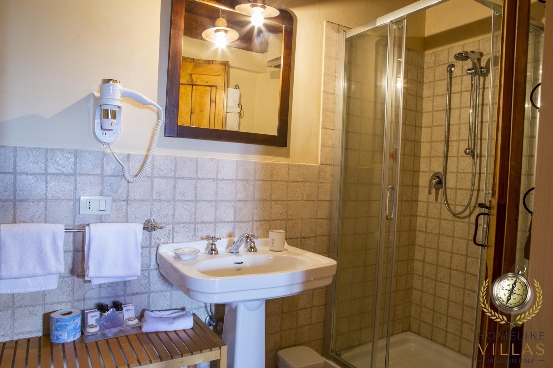 A bathroom with a sink, mirror, and shower.