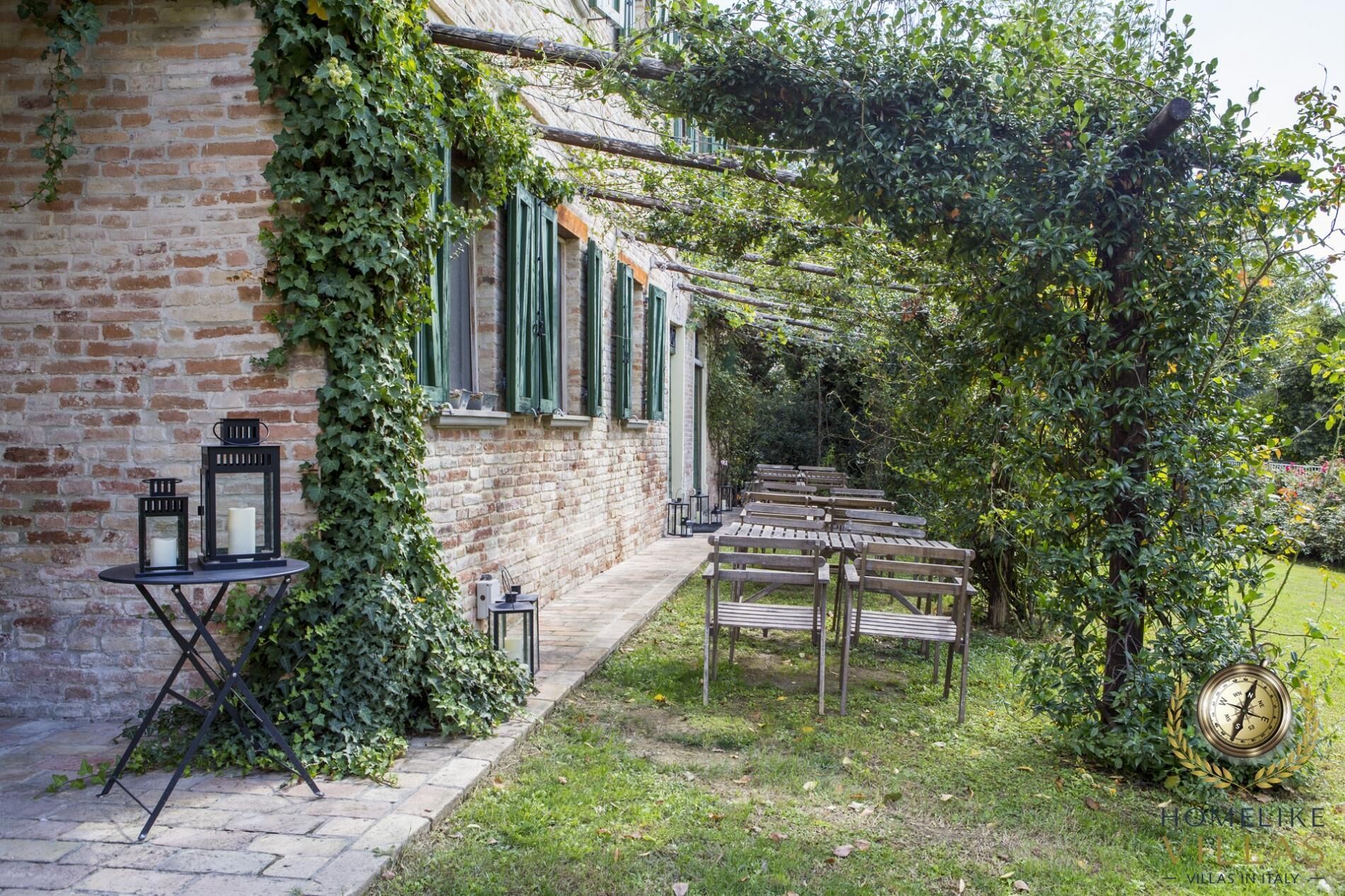 Un bâtiment rustique en briques, doté d’un jardin agrémenté de bancs en bois et de lanternes.