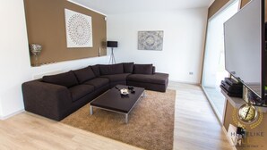 A modern living room with a sectional sofa, a coffee table, and artwork on the walls. - Villa Giorgi (Cingoli)