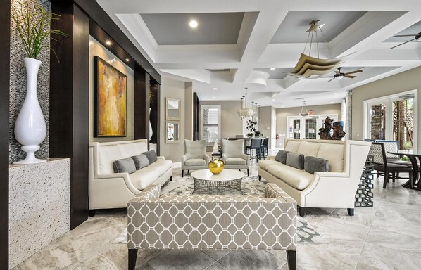 A spacious living room with a modern design, featuring a large sofa set, a coffee table, and a decorative vase.
