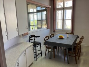 A dining area with a table, chairs, and a window with a view.