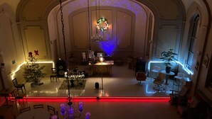 A spacious room with a Christmas tree, a chandelier, and a Christmas wreath on the wall. - The Couvent (Sainte-Anne-des-Monts)