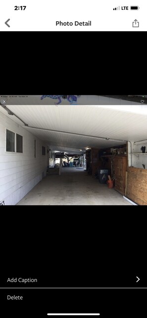 Een garage met een wit plafond en muren, vol met diverse spullen en meubels.