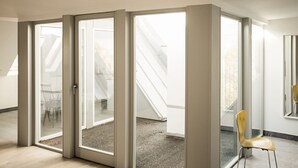A modern interior with a large sliding glass door leading to a balcony with a view of a staircase. - Gutshaus Üselitz (Poseritz)