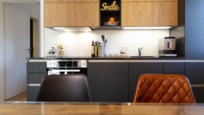Eine moderne Küche mit Holzausstattung, einem Einbauofen und einer Kaffeemaschine.