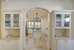 A kitchen with white cabinetry, a central island, and a ceiling light fixture. - SEAesta Beach House in St Simons Island, GA (St Simons Island)