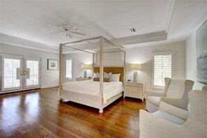 Relax in a serene bedroom with a four-poster bed, bedside tables, and a comfortable chair.