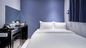 A hotel room with a bed, a desk with a telephone and a basket, and a wall-mounted mirror. - Hotel Noble Noryangjin (Seoul)