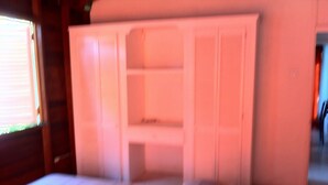 A bed with a white headboard and a small bedside table. - A spacious rustic house with modern conveniences (St. James)