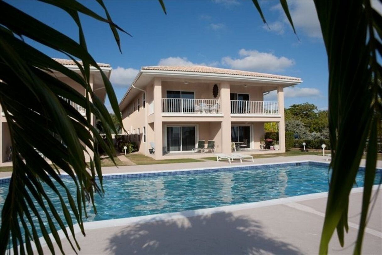 Un bâtiment à deux étages avec une piscine devant.