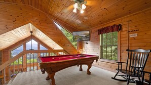 A wooden interior with a pool table, a rocking chair, and a television mounted on the wall. - Hot Tub & Pool Table + Fire Pit - Secluded (Sevierville)