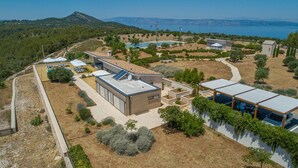 Eine moderne Villa mit Pool, Sitzgelegenheiten im Freien und Meerblick.