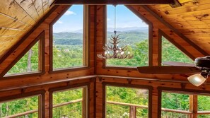 A wooden interior with multiple windows offering a view of a forested landscape. - The Appalachian- Mtn Views, Private/ Heated Indoor Pool, Game Room, Hot tub (Sevierville)