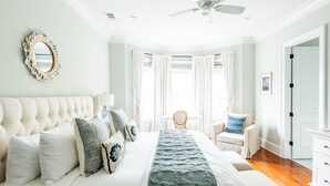Une chambre à coucher avec un grand lit, une chaise, un bureau et une armoire.