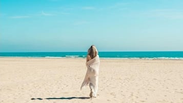 Plage à proximité, sable blanc, parasols, yoga sur la plage