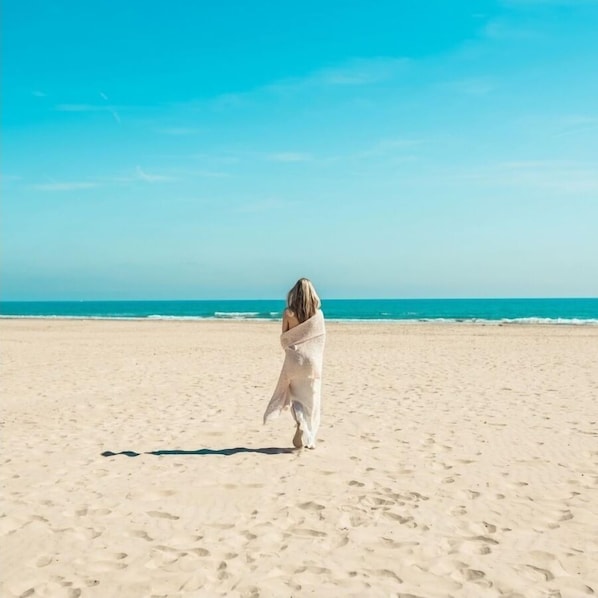 Nær stranden, hvit sand, parasoller og strandyoga