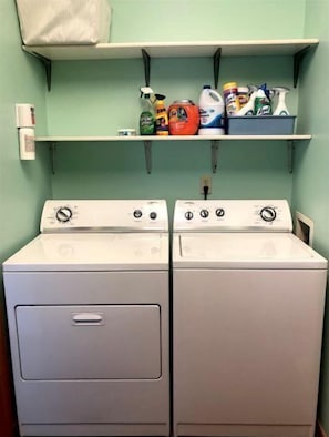 Convenient laundry facilities with two front-loading washing machines and storage for cleaning supplies.