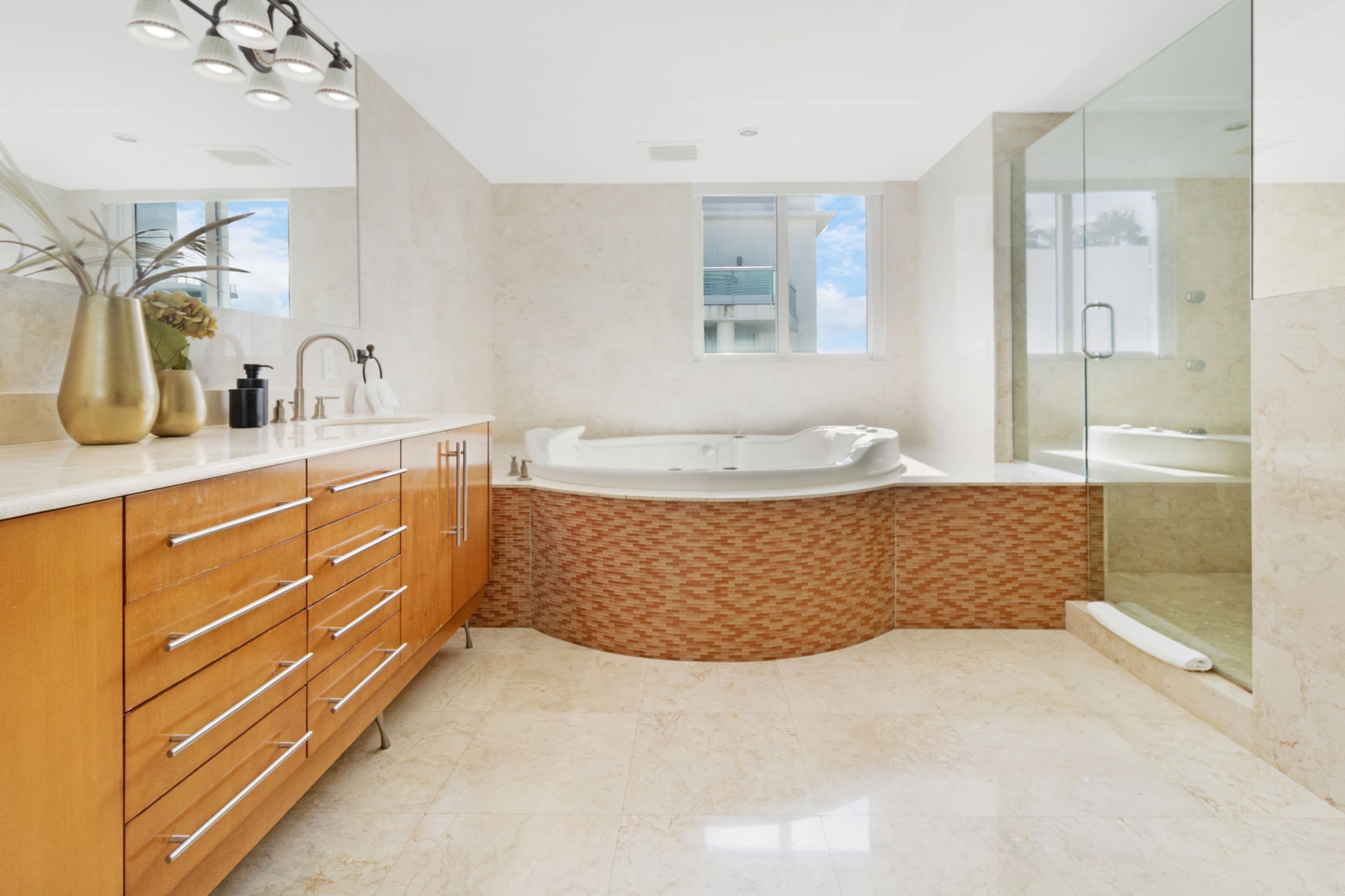 A modern bathroom with a freestanding bathtub, a glass shower enclosure, and a vanity with multiple drawers.