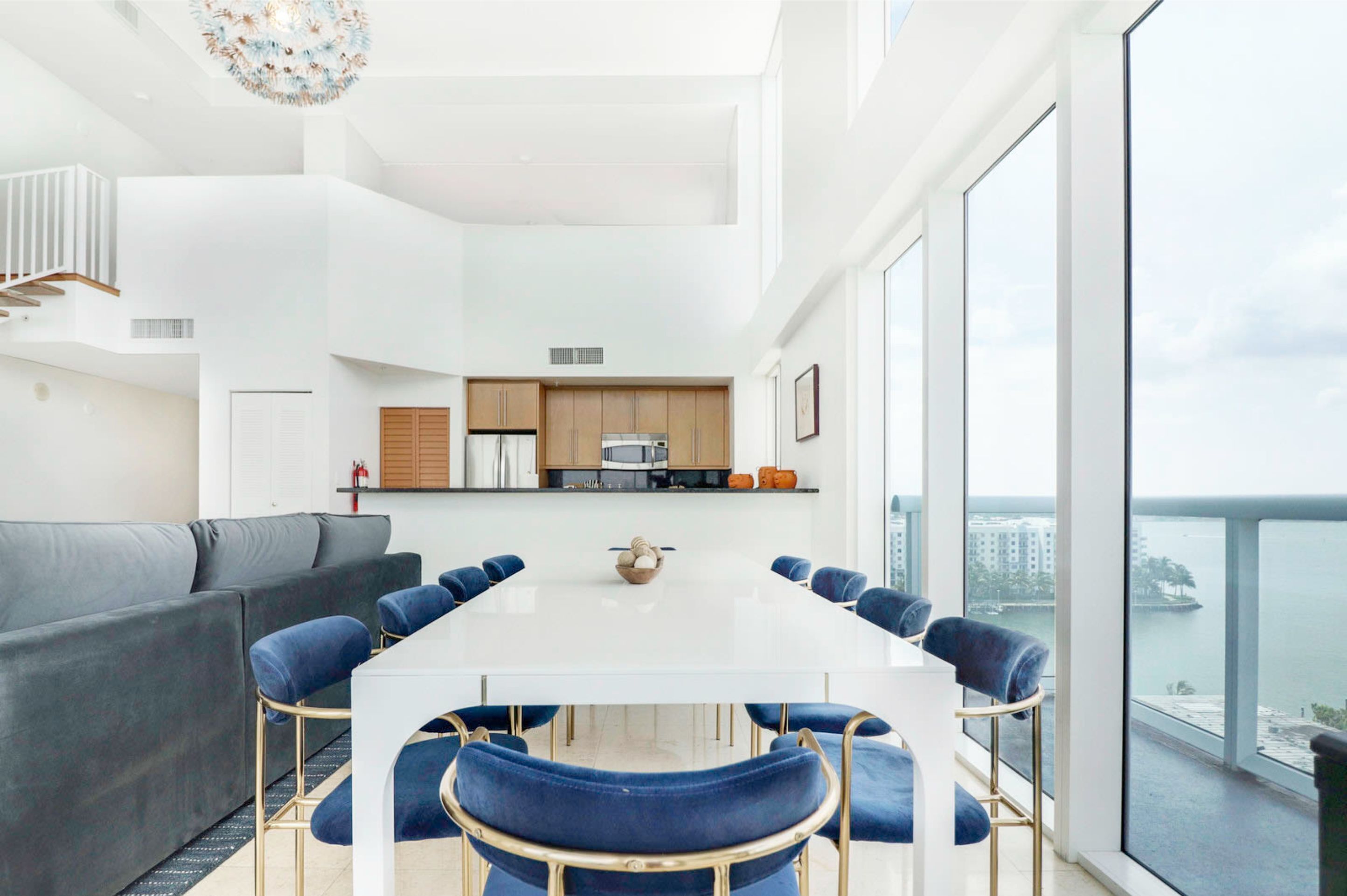 Un intérieur moderne comprenant un coin repas, une cuisine et un balcon offrant une vue sur la ville.