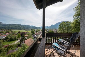 A balcony with a view of a village and mountains.