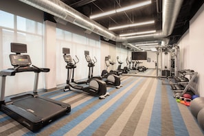 A gym with treadmills, elliptical machines, and free weights. - Aloft by Marriott Omaha Aksarben Village (Omaha)